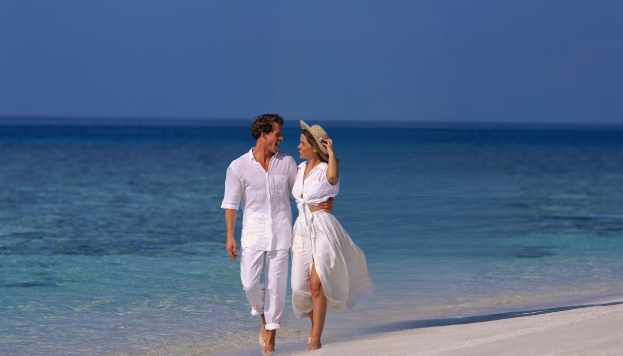 Couple walking on the beach promoting Cambridge Currencies international money transfer service