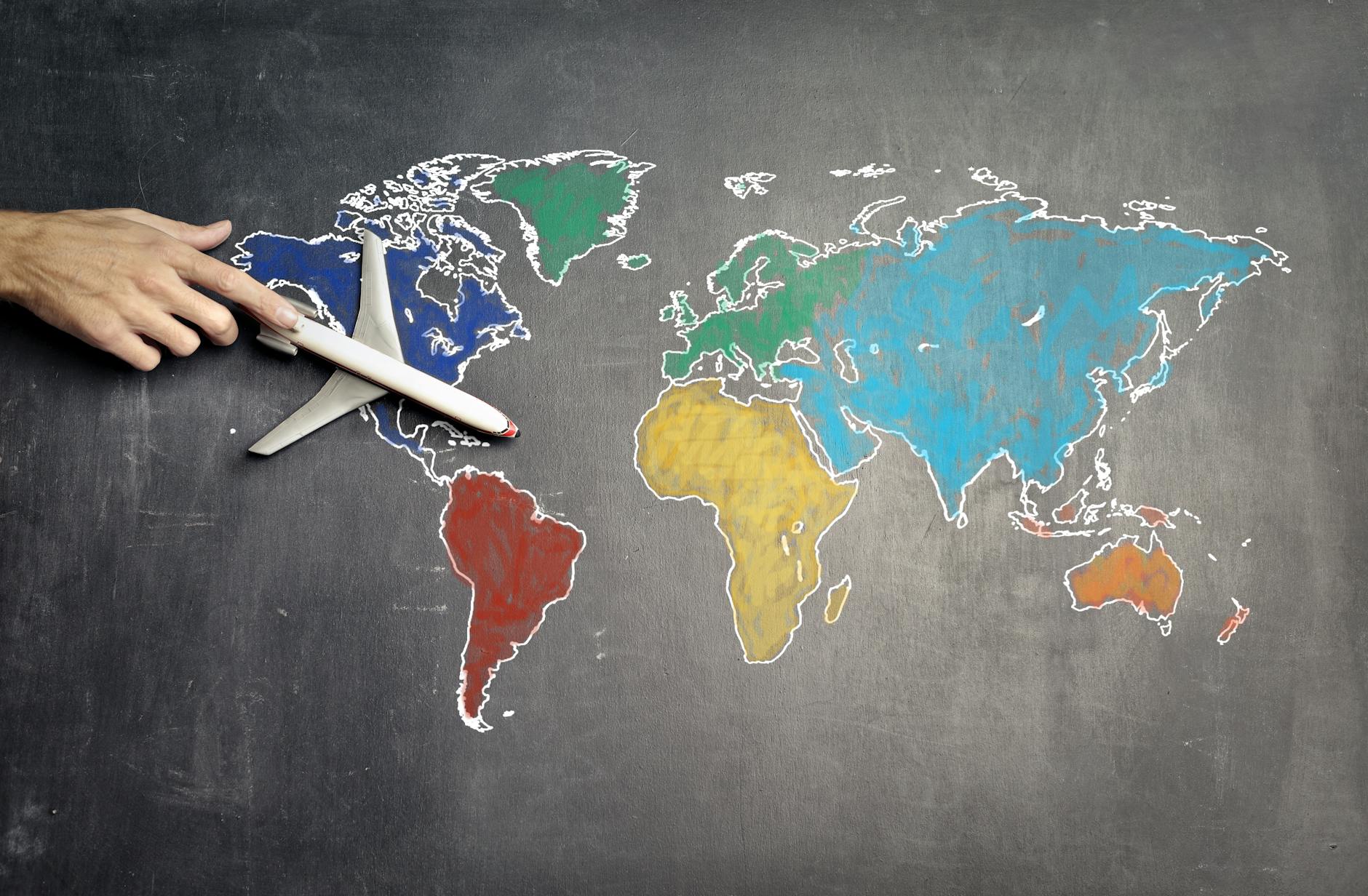 person with toy airplane on world map showing Relocation Specialists